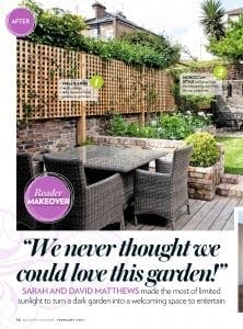 A modern garden featured in Modern Gardens Magazine, with a trellis fence, potted plants, a glass outdoor dining table for six, wicker chairs, and wooden decking set against a brick wall backdrop.